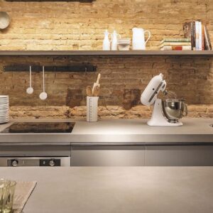 Modern kitchen with Neolith Phedra worktop against a brick wall