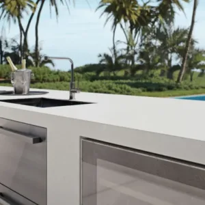 Outdoor kitchen with Caesarstone Midday Quartz worktop overlooking a pool