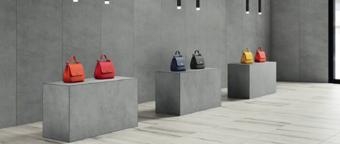 Flooring Modern showroom featuring Laminam Seta Gris walls with colourful handbags on display.