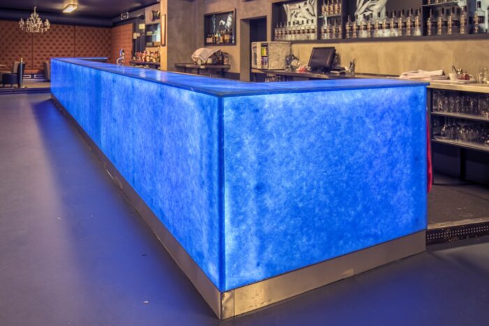 Flooring Illuminated bar counter made from Magna Glaskeramik Ocean Blue glass in a modern setting.