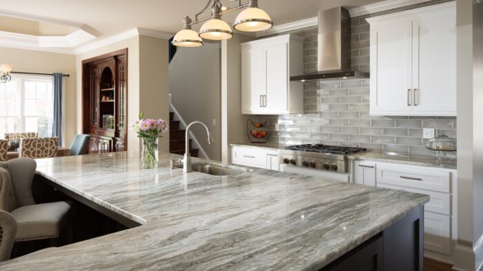 Tiles & Walls Elegant kitchen featuring Fantasy Brown Marble worktop with white cabinetry.