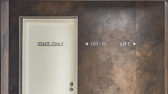 Tiles & Walls Laminam Ossido Bruno wall panel in a commercial setting with signage