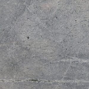 Close-up of Atlantic Sky Blue Marble with dark veins on a blue-grey background