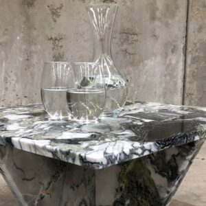 Elegant table made from Primavera Marble with water glasses in an industrial setting