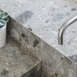 Ceralsio Ocean Stone kitchen countertop with plants and a tap.