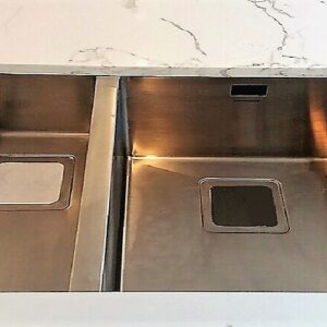 Stainless steel sink installed on Cimstone Calacatta Venato quartz countertop.