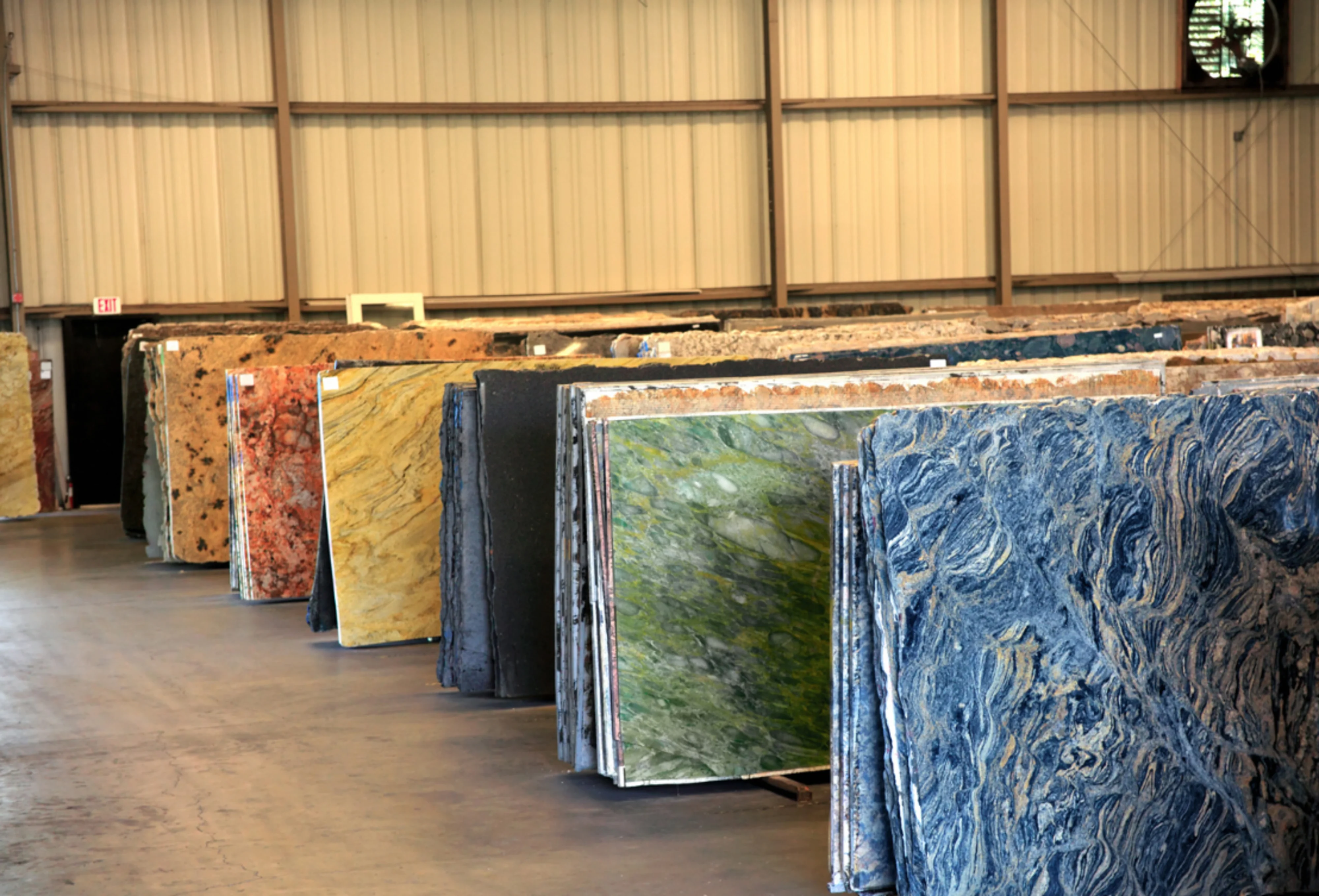 A series of colourful slabs of granite in a warehouse