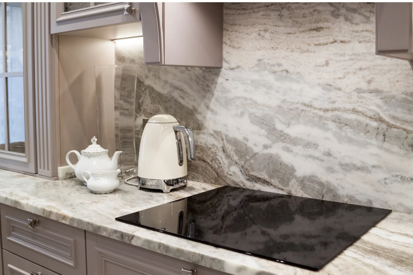 How to add value to your home. A grey kitchen worktop with a grey stone wall and a white kettle.